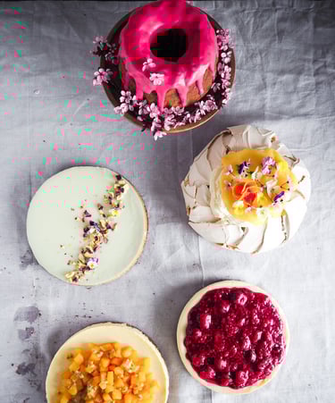 Kolorowe ciasta ustawione na jasnym obrusie widziane z góry