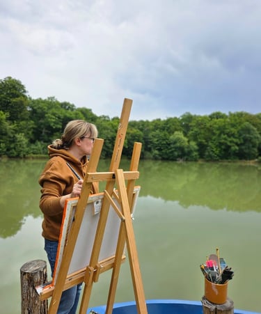 Severine Bugna en train de peindre au bord d'un étang