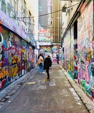 a person walking down a narrow alley with graffiti on the walls