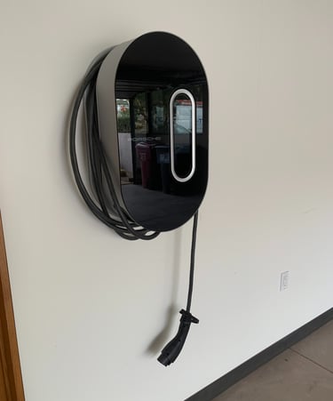 A wall-mounted Porsche electric vehicle charger in a home garage with a wrapped charging cable.