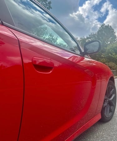 Red Dodge Charger parked on a residential street in Fletcher, NC