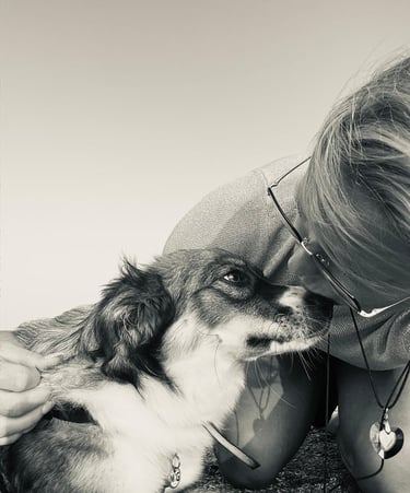 hond en vrouw die elkaar een kus geven