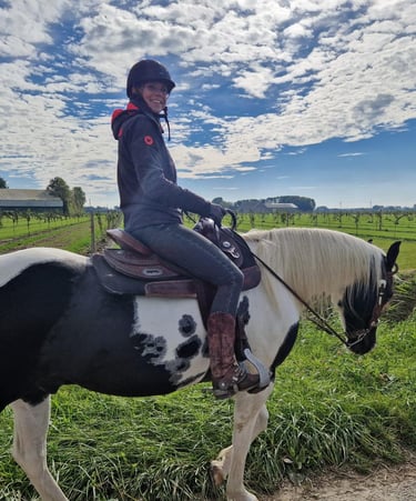 a woman riding a horse in a field