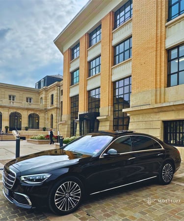 Luxury black Mercedes-Benz S-Class sedan parked in front of an luxury champagne house