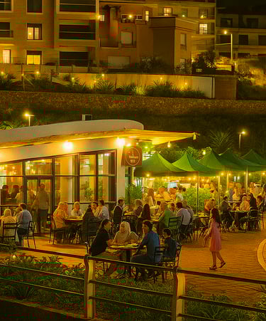 مطعم حيث يجلس الناس على الطاولات ويأكلون على أضواء ذافئة تحت القمر