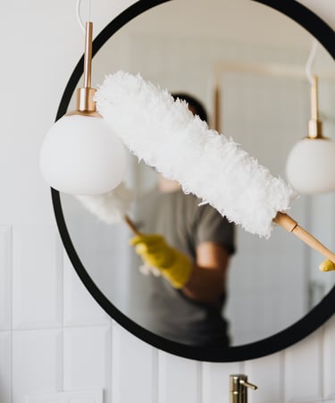 Dusting a mirror - Londoncleaningco.co.uk