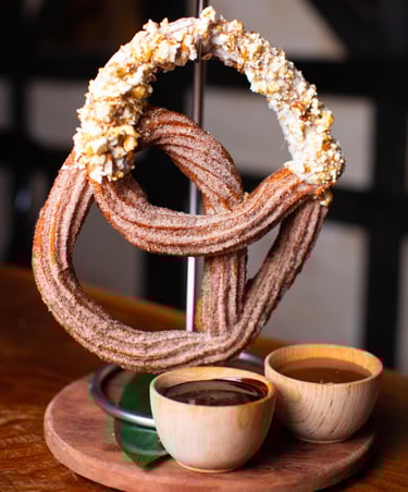 a huge churro pretzel hanging from a stand like a pretzel