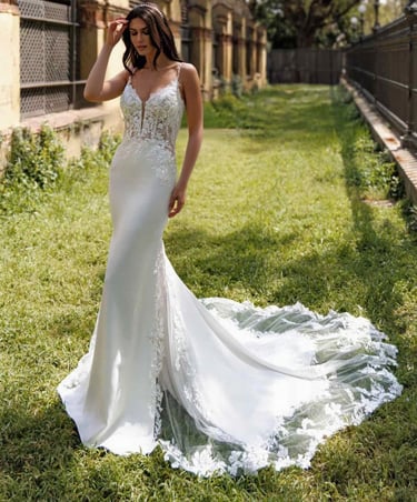 a woman in a white dress standing in the grass
