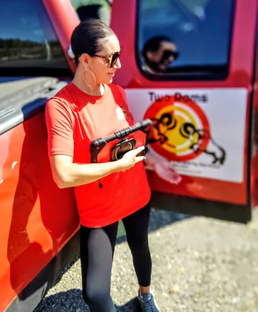 a woman in a red shirt is holding a gun