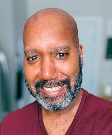 A picture of Brian, a Black person wearing a red V-neck shirt