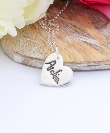 Your childs name, written by them, pressed onto a silver heart pendant
