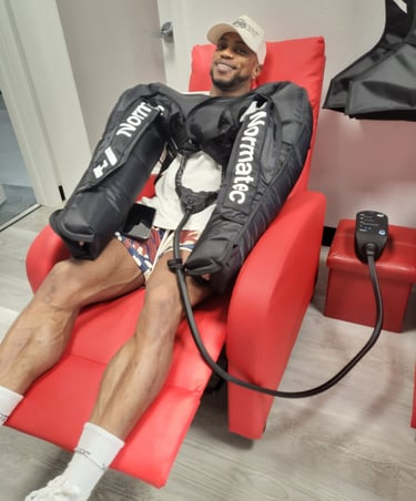 a man sitting in a chair with in an arm compression treatment