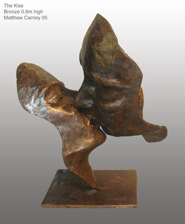a bronze sculpture of two faces kissing