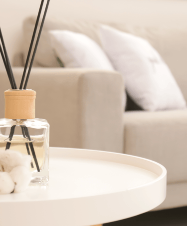 a table with a glass vase and a candle on it
