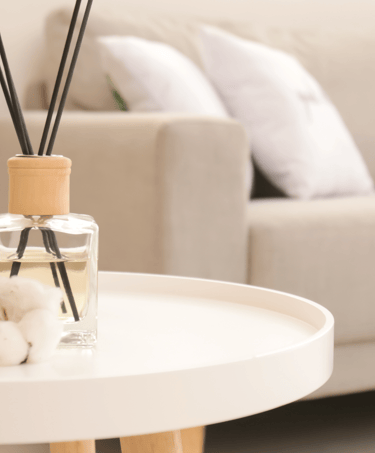 a table with a glass vase and a candle on it