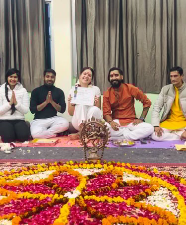 Eva standing with her yoga teachers during the diploma ceremony in Rishikesh, all smiling and celebrating the completion of t
