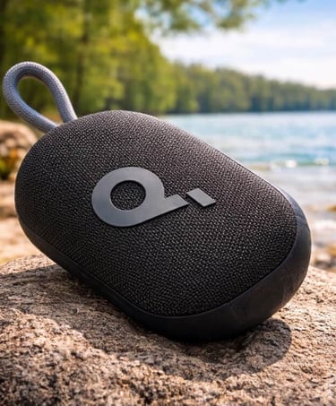 Portable Bluetooth speaker resting on a rock beside a calm lake