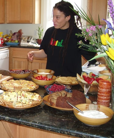 a woman standing in front of a counter top with a variety of food