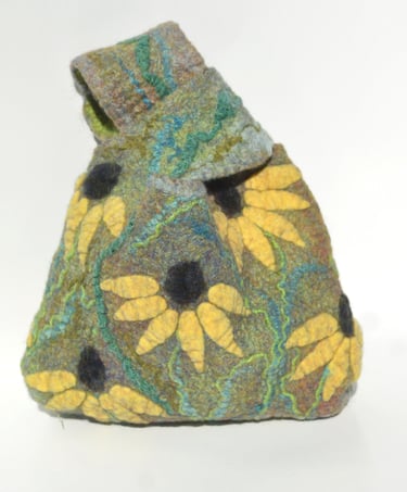 Handmade nuno felted wool bag with yellow flower patterns and a green knotted handle.
