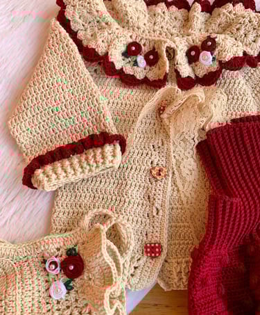 Handmade crochet baby cardigan set in cream and red with floral embroidery and lace details.