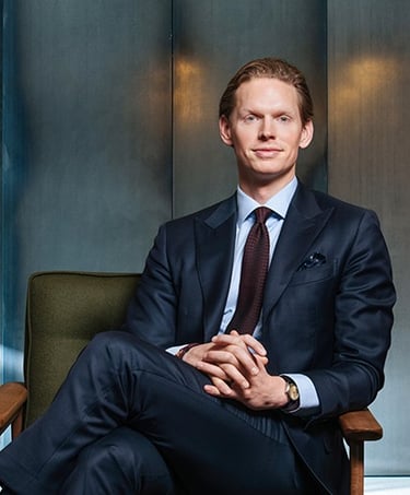 a man in a suit and tie sitting in a chair