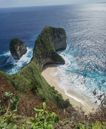Aerial view of Kelingking Beach in Nusa Penida, Bali, featuring the famous T-Rex shaped limestone cliff and turquoise ocean