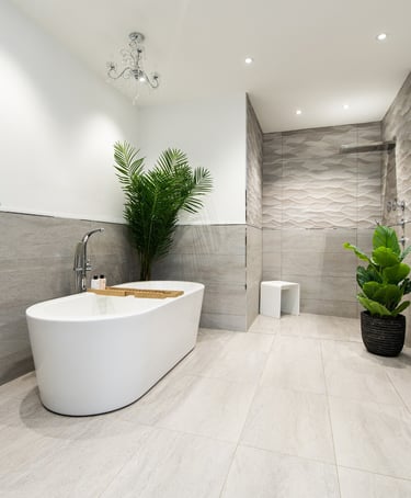 A large bathroom with freestanding bath. Pale grey tiles and white walls.