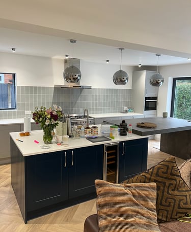 A modern kitchen with navy cabinets and a kitchen island. 