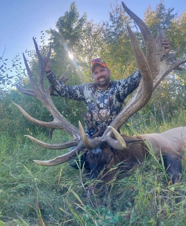 happy hunter with his giant bull elk