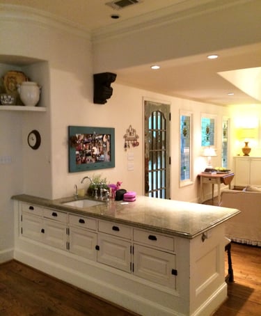 Elegant white kitchen island with granite countertop and classic cabinets in a warm home interior.