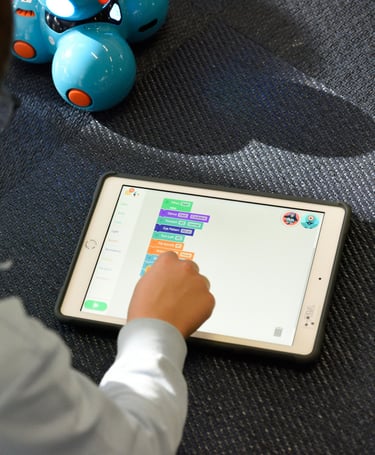 a boy playing with a tablet computer and a robot