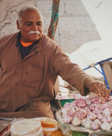 man in brown jacket selling spices in souk