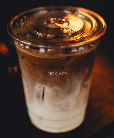 a cup of coffee with a candle on a table