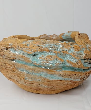 Estelle Del oeuvre artistique d'un pot en grès roux texturé émaillé en vert, inspirée des fa:laises 