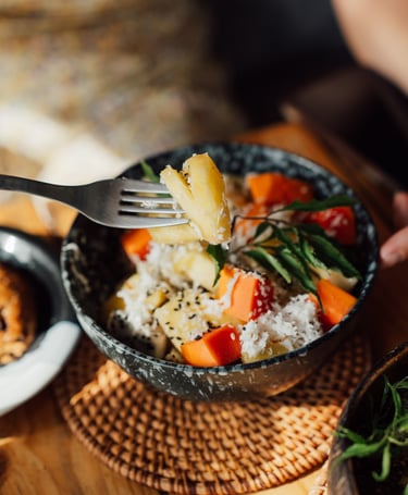 a person holding a fork and fork in a bowl