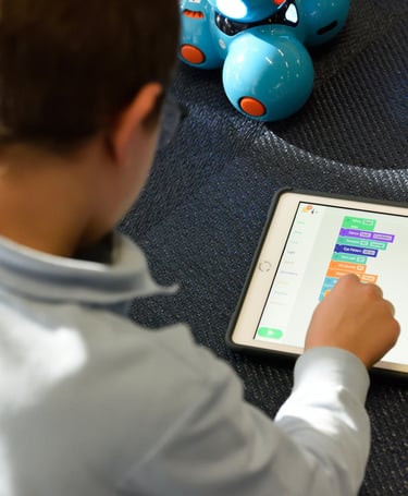 a boy playing with a tablet computer and a robot