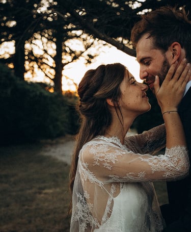 a bride and groom kissing in a field