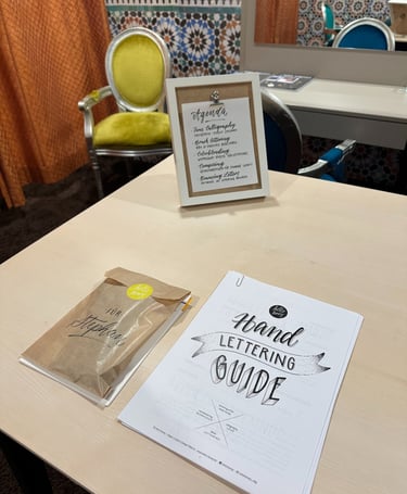 Hand lettering guide and calligraphy workshop materials on a table for a creative art class.
