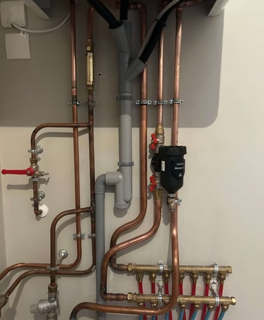 Filtre à boue Sentinel installé sous une chaudière lors d'un remplacement de chaudière