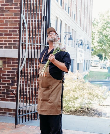 a man in a apron and hat with a canelle