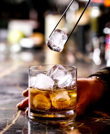 Μπάρμαν προσθέτει πάγο σε ποτήρι με ποτό