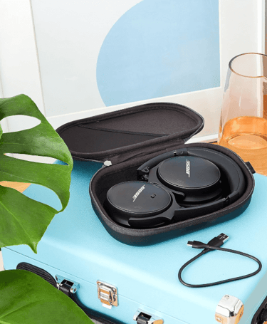 a suitcase case with a pair of headphones and a glass of water