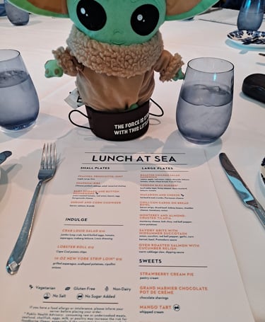 Little Green Companion sitting on table with Lunch menu in front of him