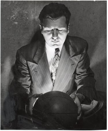 Photograph of Basketball Player Hank Luisetti starting at basket ball Stewart Chevrolets 1950