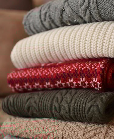 A pile of folded multicolor sweaters
