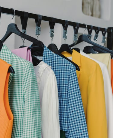 Assorted colorful women's shirts and jackets on a clothing rack
