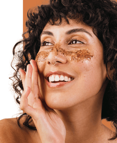 woman smiling using cafine all natural face scrub