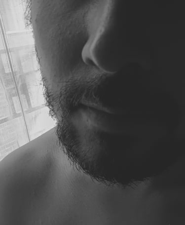 Primer plano de rostro masculino con barba en blanco y negro.