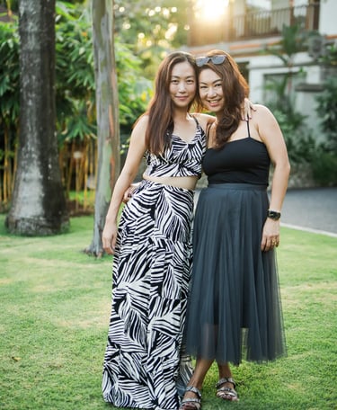 Two women friends during relaxed family photography session at Padma Resort Legian Bali garden.