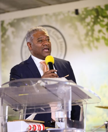 Male holding a microphone wearing tie and suit 